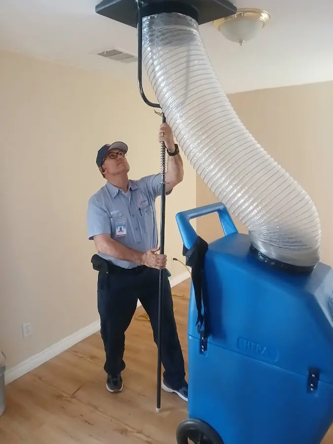 Furnace Tune-Up technician using HEPA equipment in Poinciana